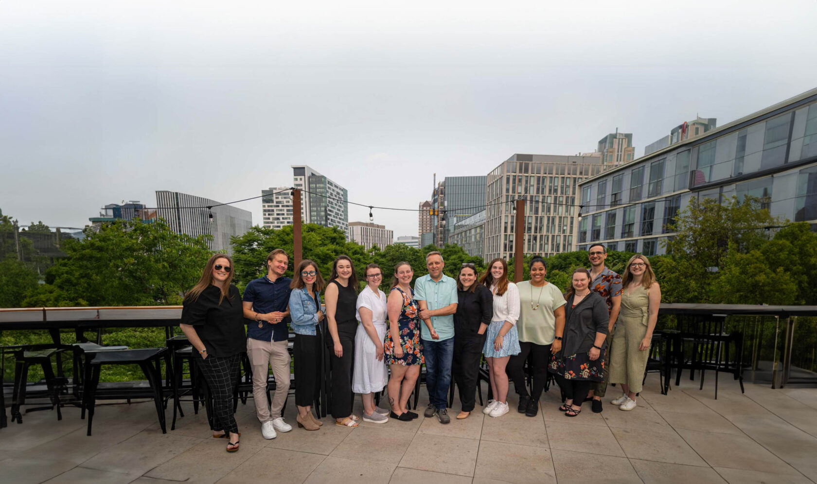 A group of people who work for Boston area food recovery organization Lovin Spoonfuls posing for a photo on a rooftop.