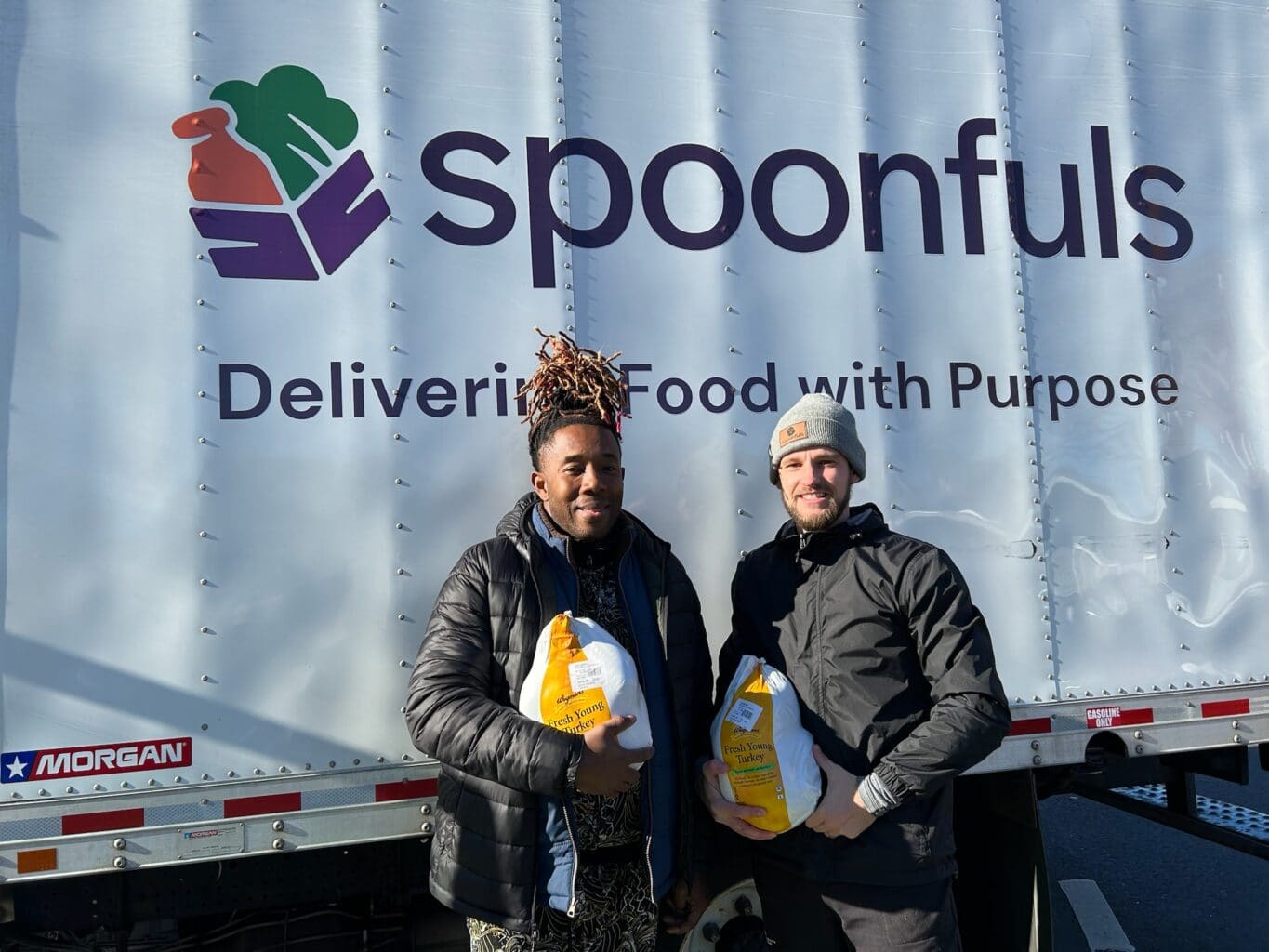 A Spoonfuls staff member and a community partners hold recovered turkeys in front of a Spoonfuls truck to help demonstrate our Core Values & Inclusion Tenets.
