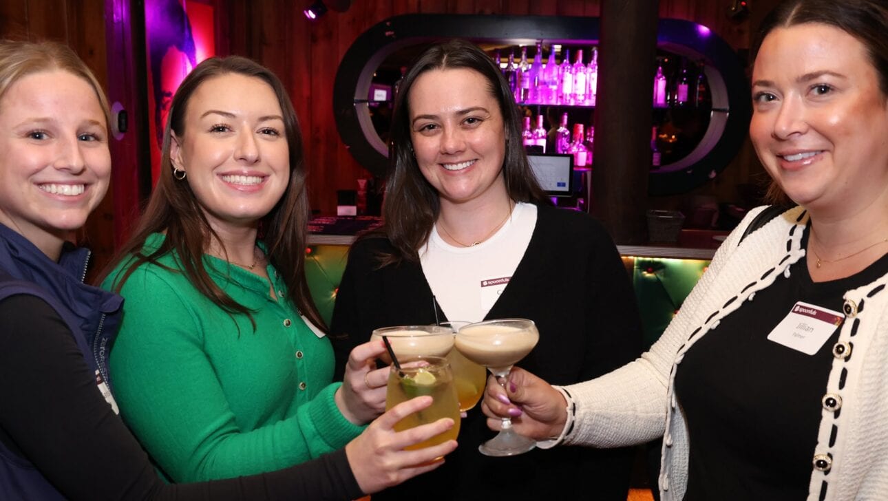 A group of young professionals cheersing cocktails at the 2025 Cocktails & Community event.