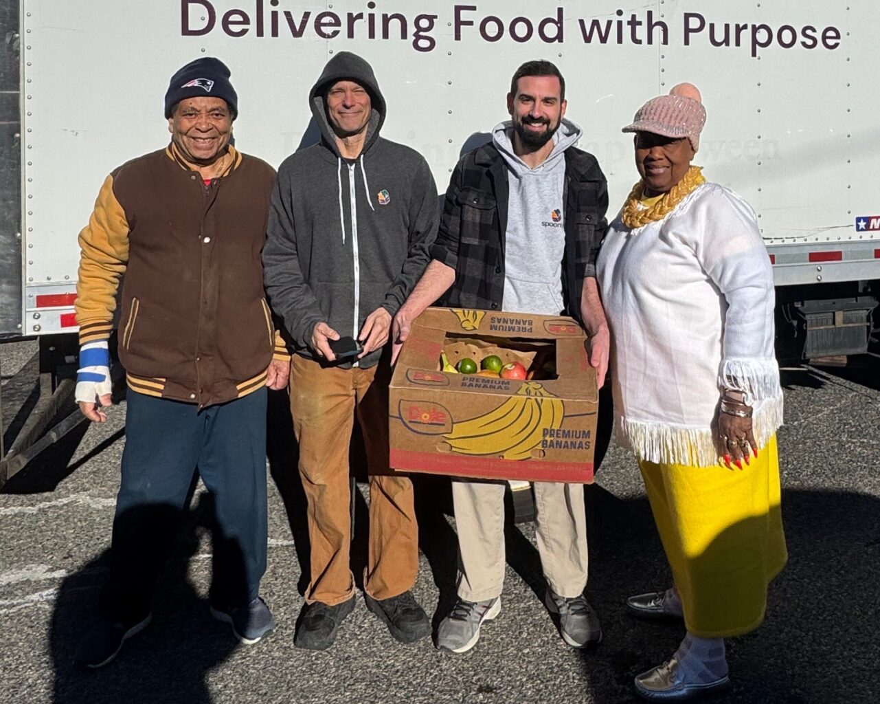 Two Spoonfuls staff members and two community partners pose in front of a Spoonfuls truck to help demonstrate our Core Values & Inclusion Tenets.